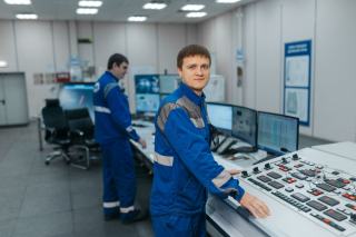 Techniciens devant un pupitre de supervision technique