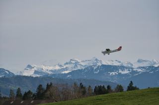 Petit avion en vol devant des sommets enneigés