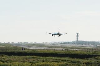 Avion en approche finale au-dessus de la piste, tour de contrôle au fond