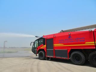 Véhicule incendie d'aéroport qui projette de l'eau